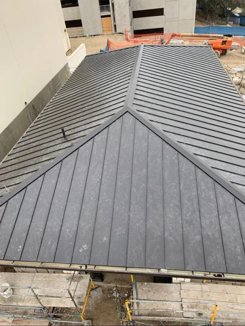 Commercial metal roof construction with crane equipment in Asbury Lake