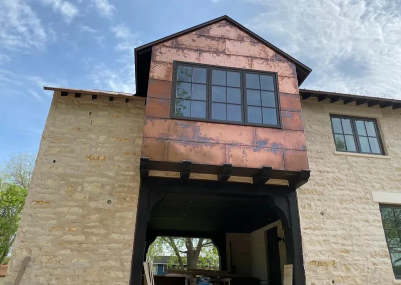 Copper metal panel facade on a stone building for Roof Repair in Asbury Lake